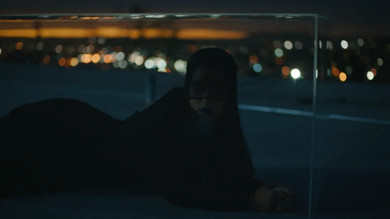 Silhouetted figure against moody city lights at night