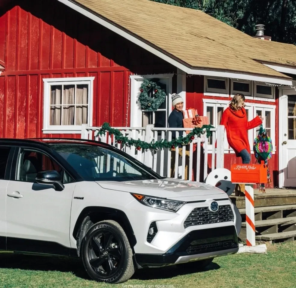 White SUV in front of holiday-decorated red house